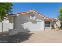 Single-story home with a two-car garage and a driveway, showcasing low-maintenance desert landscaping at 7214 W Columbine Dr, Peoria, AZ 85381