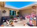 Cozy front patio with brick accents, seating area, potted plants, and charming outdoor decor at 7515 W Sweetwater Ave, Peoria, AZ 85381