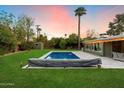 A stunning backyard features a pool, patio, shed and beautiful sunset at 7813 N 17Th Dr, Phoenix, AZ 85021