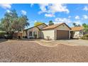 Tan home with brown roof, a single car garage, and desert landscaping at 8335 W Pershing Ave, Peoria, AZ 85381