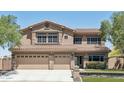 Charming two-story home features a three-car garage and well-maintained front lawn at 9570 W Quail Track Dr, Peoria, AZ 85383
