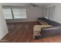 Large living room with hardwood floors, abundant natural light, and a ceiling fan at 16002 N 23Rd Ave, Phoenix, AZ 85023