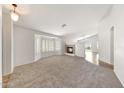 Spacious living room with carpet flooring, a fireplace, and a large window providing natural light at 16036 N 11Th Ave # 1084, Phoenix, AZ 85023