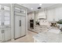 Bright kitchen featuring a modern range hood, stainless steel appliances, and marble countertops at 3117 E Maryland Ave, Phoenix, AZ 85016