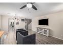 Spacious living room with light wood floors, modern light fixture, and neutral decor at 3551 E Mead Dr, Gilbert, AZ 85298