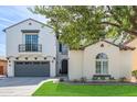 Charming two-story home with a well-kept lawn, balcony, gray garage doors and stucco exterior at 4615 E Calistoga Dr, Gilbert, AZ 85297