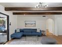 Comfortable living room with a sectional sofa, glass coffee table, and views to the backyard at 5701 E Charter Oak Rd, Scottsdale, AZ 85254