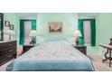 This bedroom features mint green walls, window shades, a queen-sized bed, two nightstands and a painting at 650 N Hawes Rd # 4013, Mesa, AZ 85207
