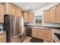 Well-lit kitchen featuring wood cabinets, granite countertops, stainless steel appliances, and a double sink at 650 N Hawes Rd # 4013, Mesa, AZ 85207