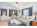 Cozy living room featuring a comfortable gray sofa, an armchair, and a decorative glass coffee table at 650 N Hawes Rd # 4013, Mesa, AZ 85207