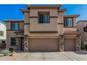 Two-story home showcasing a stucco finish, tile roofing, and a two-car garage highlighted by stone accents at 9113 W White Feather Ln, Peoria, AZ 85383
