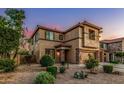 Inviting two-story home featuring a three-car garage and a desert landscaped front yard at 9113 W White Feather Ln, Peoria, AZ 85383