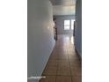 Hallway boasts tile flooring and leads to a spacious living area with natural light at 9418 W Eaton Rd, Phoenix, AZ 85037