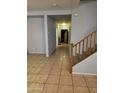 The tiled entrance hallway features a staircase, enhancing the home's open layout at 9418 W Eaton Rd, Phoenix, AZ 85037
