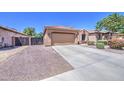 Single-story home featuring a two-car garage, desert landscaping, and a concrete driveway at 11060 E Sorpresa Ave, Mesa, AZ 85212