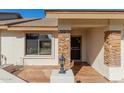 Inviting front entrance with stone accents, a security screen door, and a stylish outdoor lantern at 11250 E Kilarea Ave # 276, Mesa, AZ 85209