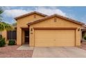 Charming front exterior view with a two-car garage and easy-care desert landscaping at 16261 W Custer Ln, Surprise, AZ 85379