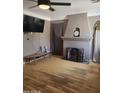 Cozy living room featuring a decorative fireplace, mantel clock, and wood laminate flooring at 1629 E Garfield St, Phoenix, AZ 85006
