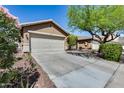 Beautiful home featuring a two-car garage, neutral colors, and desert landscaping with a green tree at 16820 N 152Nd Ln, Surprise, AZ 85374