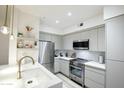 Modern kitchen with stainless steel appliances, white countertops, and ample cabinet space at 1701 E Colter St # 488, Phoenix, AZ 85016