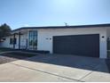 Contemporary home featuring a spacious garage, well-maintained lawn, and modern exterior lighting at 1920 N Cavalier Dr, Tempe, AZ 85288