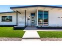 Charming modern home with green lawn, crisp white paint, elegant dark trim, and minimalist desert landscaping at 1920 N Cavalier Dr, Tempe, AZ 85288