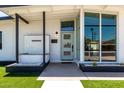 Charming modern home with green lawn, crisp white paint, elegant dark trim, and minimalist desert landscaping at 1920 N Cavalier Dr, Tempe, AZ 85288