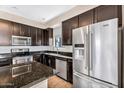 Modern kitchen featuring dark cabinets, granite countertops, stainless steel appliances, and an island at 2090 S Dorsey Ln # 1037, Tempe, AZ 85282