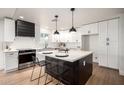Beautiful kitchen featuring white cabinetry, a center island with seating, and pendant lighting at 2345 E Isabella Ave, Mesa, AZ 85204