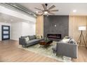 Modern living room featuring stylish sofas, ceiling fan, wood accent wall, and a decorative fireplace at 2345 E Isabella Ave, Mesa, AZ 85204