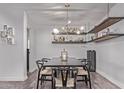 Stylish dining room with a modern chandelier, bar shelves, and seating for six at 3323 N 28Th St, Phoenix, AZ 85016