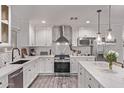 Modern, all-white kitchen featuring marble countertops, stainless steel appliances, and pendant lighting at 3323 N 28Th St, Phoenix, AZ 85016