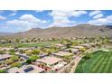 A high angle showcases community homes adjacent to the golf course, framed by the majestic mountains at 42109 N Astoria Way, Anthem, AZ 85086