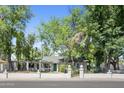 Traditional home with a well-manicured lawn, mature trees, and a decorative white brick fence at 430 N Vineyard --, Mesa, AZ 85201