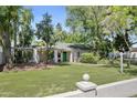 Quaint single story home with a manicured lawn, trees, and a white brick fence at 430 N Vineyard --, Mesa, AZ 85201