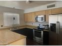 Modern kitchen featuring stainless steel appliances, light wood cabinets, and dark countertops, creating a stylish and functional space at 5708 S Beck Ave, Tempe, AZ 85283