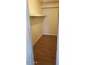 An empty walk-in closet with a built-in shelf and wood flooring providing ample storage and organization space at 5708 S Beck Ave, Tempe, AZ 85283