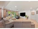 Bright living room with exposed brick, a plush sectional, and natural light at 5812 N 18Th Pl, Phoenix, AZ 85016