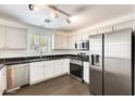 Bright kitchen with white cabinets, stainless steel appliances, and dark countertops at 6830 W Desert Ln, Laveen, AZ 85339