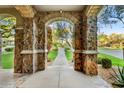 Stone archway frames a view of the landscaped front yard, creating a grand entrance at 9087 E Mountain Spring Rd, Scottsdale, AZ 85255