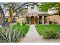 Charming home with a stone archway, lush landscaping and walkway leading to the front door at 9087 E Mountain Spring Rd, Scottsdale, AZ 85255