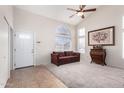 Living room with vaulted ceiling, ceiling fan, carpet, and front door entry at 9662 W Sunnyslope Ln, Peoria, AZ 85345