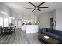 Open floor plan with kitchen, dining area, and living room featuring high ceilings and wood-look floors at 13018 W Pershing St, El Mirage, AZ 85335