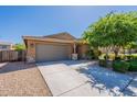 Charming single-story home with a two-car garage, stone accents, and well-manicured landscaping at 18801 W Yucatan Dr, Surprise, AZ 85388