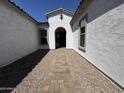 Inviting entrance showcasing a paved walkway leading to the front door and a charming covered porch at 26232 N 77Th Dr, Peoria, AZ 85383