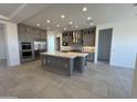 Open kitchen boasts a large center island, stainless steel appliances, and ample cabinet space, perfect for modern living at 26232 N 77Th Dr, Peoria, AZ 85383