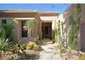 Inviting home exterior featuring desert landscaping, a tiled roof, and a covered entryway at 6714 E Amber Sun Dr, Scottsdale, AZ 85266