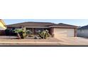 Well-maintained single-story brick home showcasing desert landscaping and an attached two-car garage at 8025 E Medina Ave, Mesa, AZ 85209