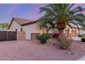 Landscaped side yard with desert rock and a privacy gate with a glimpse of the home's exterior at 1019 N Tambor Cir, Mesa, AZ 85207