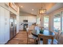 Bright kitchen with white cabinetry, stainless steel appliances, and a cozy dining area near the window at 11447 N 109Th St, Scottsdale, AZ 85259